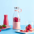 Pink portable blender filled with raspberries