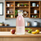 Pink portable blender with juice on a kitchen counter