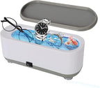 Ultrasonic jewellery cleaner with glasses, a watch and a ring inside